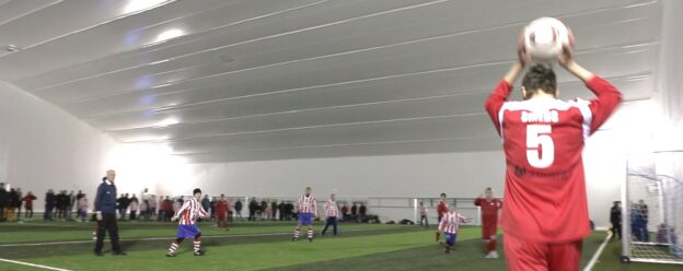 Kids playing indoor football with sports canopy roof